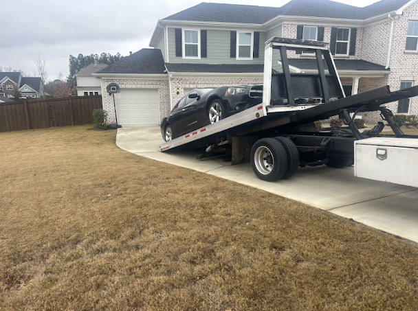 Vehicle recovery from a residential driveway with a tilted flatbed